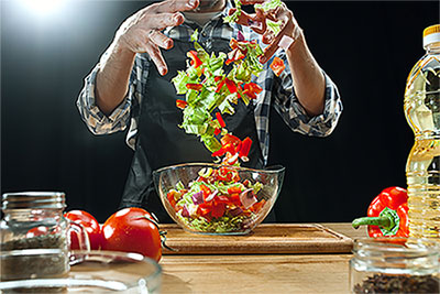 Preparing salad. Female chef cutting fresh vegetables. Cooking process. Selective focus